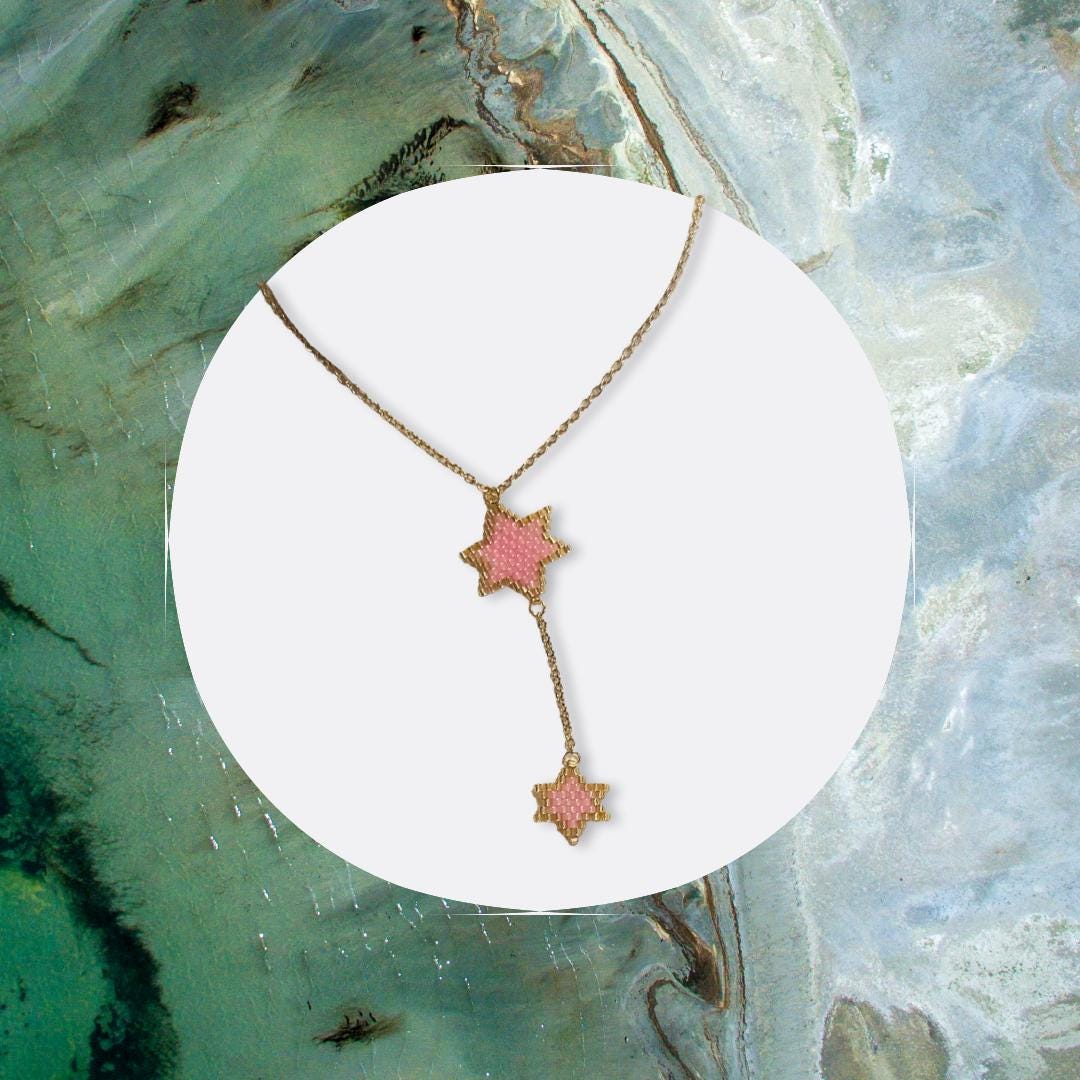 Handmade Double Star of David beaded necklace in pink and gold on display